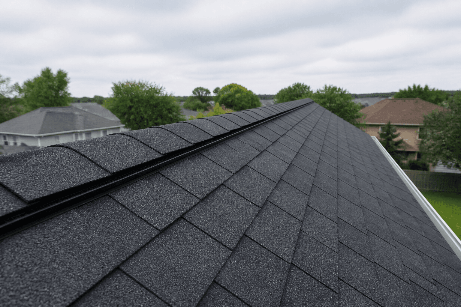 Finished charcoal architectural roof with ridge-cap shingles over the peak